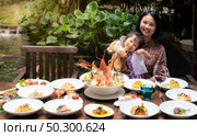 Portrait of mom and daughtersit at garden of restaurant of lobster shrimp steak beef lamb pasta spaghetti risotto rice sushi sashimi and wine using for buffet food drink background. Стоковое фото, агентство Ingram Publishing / Фотобанк Лори