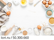 Baking homemade bread on white kitchen worktop with ingredients for cooking, culinary background, copy space, overhead view. Стоковое фото, агентство Ingram Publishing / Фотобанк Лори