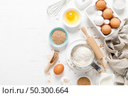 Baking homemade bread on white kitchen worktop with ingredients for cooking, culinary background, copy space, overhead view. Стоковое фото, агентство Ingram Publishing / Фотобанк Лори
