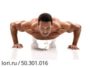 Muscle man making pushups in studio, isolated over a white background. Стоковое фото, агентство Ingram Publishing / Фотобанк Лори