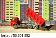 Building urban scene. Multistorey building apartment house and dump truck unload soil at day. Стоковое фото, агентство Ingram Publishing / Фотобанк Лори