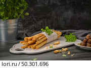 Fresh baked homemade grissini bread sticks in white ceramic tray with olive oil and basil herbs over kitchen counter top. Стоковое фото, агентство Ingram Publishing / Фотобанк Лори