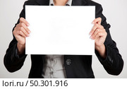 Woman holding a blank paper sheet with both hands. Стоковое фото, агентство Ingram Publishing / Фотобанк Лори