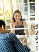 Asian young couple eating out together at new normal social distance restaurant with table shiled partition reduce infection of coronavirus covid-19 pandemic. Restaurant new normal lifestyle. Стоковое фото, агентство Ingram Publishing / Фотобанк Лори