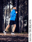 Athletic man doing exercise, running in the forest. Стоковое фото, агентство Ingram Publishing / Фотобанк Лори