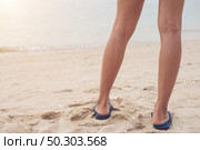 Young woman legs in flipflop sandals on sea beach. Стоковое фото, агентство Ingram Publishing / Фотобанк Лори