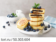 Fluffy souffle pancakes with chocolate filling and fresh blueberry for breakfast. Стоковое фото, агентство Ingram Publishing / Фотобанк Лори