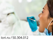 Medical staff with PPE suit test coronavirus covid-19 to asian woman by throat swab at home. New normal health care service at home and medical delivery and COVID-19 testing concept. Стоковое фото, агентство Ingram Publishing / Фотобанк Лори
