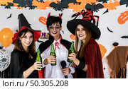 Portrait group of friends asian young adult people celebrate Halloween party carnival festive. They wear Halloween costume sing a song and cheers. Halloween celebrate and international holiday concept. Стоковое фото, агентство Ingram Publishing / Фотобанк Лори