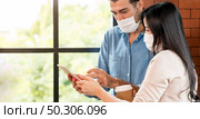 Panoramic Two business person standing for brainstorm and discuss their work with digital tablet. They wear protective face mask in new normal office preventing coronavirus COVID-19 spreading. Стоковое фото, агентство Ingram Publishing / Фотобанк Лори