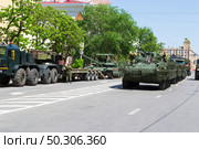Военная техника, бронетранспортёры БТР-82М, и танк Т-80 БВМ и автомобиль БАЗ-6403, трейлер, подготовка к параду Победы. Волгоград, улица Мира, Россия. (2024 год). Редакционное фото, фотограф Андрей Цыганков / Фотобанк Лори