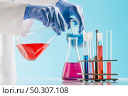 Experiments in a chemistry lab. conducting an experiment in the laboratory with humen hands. Experiments in a chemistry lab. conducting an experiment in the laboratory. Стоковое фото, агентство Ingram Publishing / Фотобанк Лори