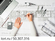 Hand over Construction plans with yellow helmet and drawing tools on blueprints. Hand over Construction plans with yellow helmet and drawing tools on blueprints . Стоковое фото, агентство Ingram Publishing / Фотобанк Лори