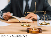 Golden justice scale in front of lawyer. Стоковое фото, агентство Ingram Publishing / Фотобанк Лори