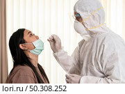 Medical staff with PPE suit test coronavirus covid-19 to asian woman by nose swab at hosputal. COVID-19 testing health care concept. Стоковое фото, агентство Ingram Publishing / Фотобанк Лори