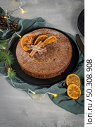 Christmas orange cake decorated with dried oranges on Christmas decorated kitchen countertop. Стоковое фото, агентство Ingram Publishing / Фотобанк Лори