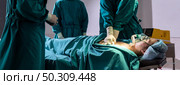 Panorama Surgeon doctor and nurse do CPR to patient while patient have problem with Sudden Cardiac Arrest while surgery in Operating Room OR. Medical health care Surgery concept. Стоковое фото, агентство Ingram Publishing / Фотобанк Лори