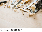 Still life of carpentry tools on wooden table background, shaving scattered everywhere, close-up shot. Стоковое фото, агентство Ingram Publishing / Фотобанк Лори