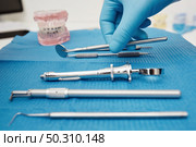Set of metal medical equipment tools for teeth dental care. Doctor takes medical instruments. Hand of dentist reaching for dental instruments in a cabinet. Set of metal medical equipment tools for teeth dental care. Стоковое фото, агентство Ingram Publishing / Фотобанк Лори