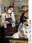 Asian waitress take order from mobile phone for takeout and curbside pickup orders while city lockdown. They wear protective face mask to prevent from infection of coronavirus COVID-19 pandemic. Стоковое фото, агентство Ingram Publishing / Фотобанк Лори