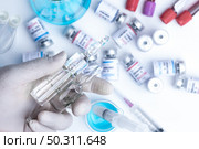 virus vaccine development of a coronavirus COVID-19, vaccine bottle in concept of insurance and fight against coronavirus 2019 ncov cure, medical research in laboratory to stop the spread of the virus. Стоковое фото, агентство Ingram Publishing / Фотобанк Лори