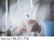 professional doctor and nurse are wearing PPE suit protection and looking for coronavirus covid-19 virus infected patient’s in hospital laboratory. Стоковое фото, агентство Ingram Publishing / Фотобанк Лори