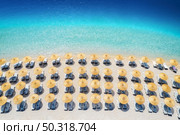 Aerial view of sea, empty sandy beach with sunbeds and umbrellas at sunny day in summer. Blue lagoon in Oludeniz, Turkey. Tropical landscape with clear turquoise water, deck chairs. Travel and leisure. Стоковое фото, агентство Ingram Publishing / Фотобанк Лори
