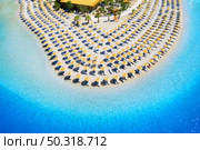 Aerial view of sea, empty sandy beach with sunbeds and umbrellas at sunny day in summer. Blue lagoon in Oludeniz, Turkey. Tropical landscape with clear turquoise water, deck chairs. Travel and leisure. Стоковое фото, агентство Ingram Publishing / Фотобанк Лори