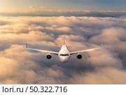 Airplane is flying above the clouds at sunrise in summer. Landscape with passenger airplane, beautiful clouds, mountains, sky. Aircraft is taking off. Business travel. Commercial plane. Aerial view . Стоковое фото, агентство Ingram Publishing / Фотобанк Лори