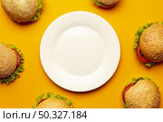 flat lay burgers with empty plate. High resolution photo. flat lay burgers with empty plate. High quality photo. Стоковое фото, агентство Ingram Publishing / Фотобанк Лори