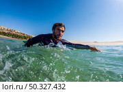 Bodyboarder rowing over the water in Furadouro beach, Ovar - Portugal. Стоковое фото, агентство Ingram Publishing / Фотобанк Лори