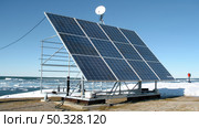 A massive solar panel collecting sunlight on the sandy shore of a beach, harnessing renewable energy for sustainable power generation. Стоковое AI-изображение, AI-художник Данила Большаков / Фотобанк Лори