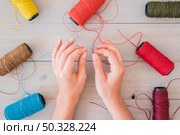 woman s hand inserting blue yarn needle wooden table. High resolution photo. woman s hand inserting blue yarn needle wooden table. Стоковое фото, агентство Ingram Publishing / Фотобанк Лори