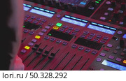 A close-up a DJ's hand adjusting a sound mixing console. The colorful buttons and sliders create a dynamic atmosphere, highlighting the art of sound manipulation. Стоковое видео, видеограф Воловодов Владимир / Фотобанк Лори