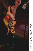 The musician skillfully plays a beautiful bass guitar, fingering the strings, surrounded by soft stage lighting. Playing a five-string bass. Стоковое видео, видеограф Воловодов Владимир / Фотобанк Лори