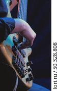 Close-up of a bass guitarist's hand skillfully playing a bass guitar in soft blue light. Concert jazz band. Стоковое видео, видеограф Воловодов Владимир / Фотобанк Лори