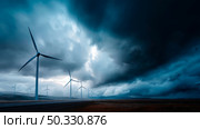 Dark shelf cloud preceding a severe thunderstorm at a wind turbine park. Beautiful thunderstorm black clouds and clouds hanging over the ground. Стоковое AI-изображение, AI-художник ALLA YURTAYEVA / Фотобанк Лори