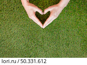 person making heart his hands grass. High resolution photo. person making heart his hands grass. High quality photo. Стоковое фото, агентство Ingram Publishing / Фотобанк Лори
