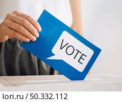 OLYMPUS DIGITAL CAMERA. High resolution photo. front view woman putting voting message box close up. High quality photo. Стоковое фото, агентство Ingram Publishing / Фотобанк Лори