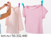 woman fixing t shirts clothesline with clothes pins. High resolution photo. woman fixing t shirts clothesline with clothes pins. High quality photo. Стоковое фото, агентство Ingram Publishing / Фотобанк Лори