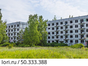Abandoned Soviet Era Apartment Blocks in Irbene Ghost Town Latvia Overgrown by Nature. Стоковое фото, фотограф Zydrius Tartenis / Фотобанк Лори