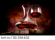 Wine in a decanter and glass on a wooden table. Wine in a decanter and glass. Стоковое фото, агентство Ingram Publishing / Фотобанк Лори