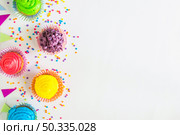 elevated view colorful muffins bunting white surface. Стоковое фото, агентство Ingram Publishing / Фотобанк Лори