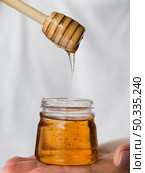 OLYMPUS DIGITAL CAMERA. honey dripping from dipper. Стоковое фото, агентство Ingram Publishing / Фотобанк Лори