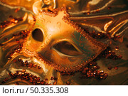 overhead view elegant gold venetian mask golden textile with sequins. Стоковое фото, агентство Ingram Publishing / Фотобанк Лори