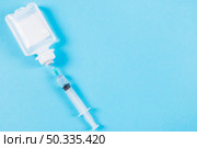 syringe inserted normal saline solution plastic bottle blue background. Стоковое фото, агентство Ingram Publishing / Фотобанк Лори