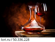 Wine in a decanter and glass on a wooden table. Wine in decanter and glass. Стоковое фото, агентство Ingram Publishing / Фотобанк Лори