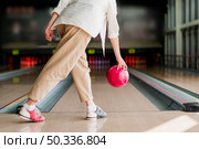 person throwing red bowling ball. Стоковое фото, агентство Ingram Publishing / Фотобанк Лори