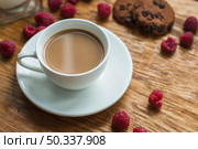white cup coffee with chocolate cookies raspberries wooden background. Стоковое фото, агентство Ingram Publishing / Фотобанк Лори