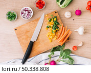 overhead view chopping board with knife vegetables wooden desk. Стоковое фото, агентство Ingram Publishing / Фотобанк Лори